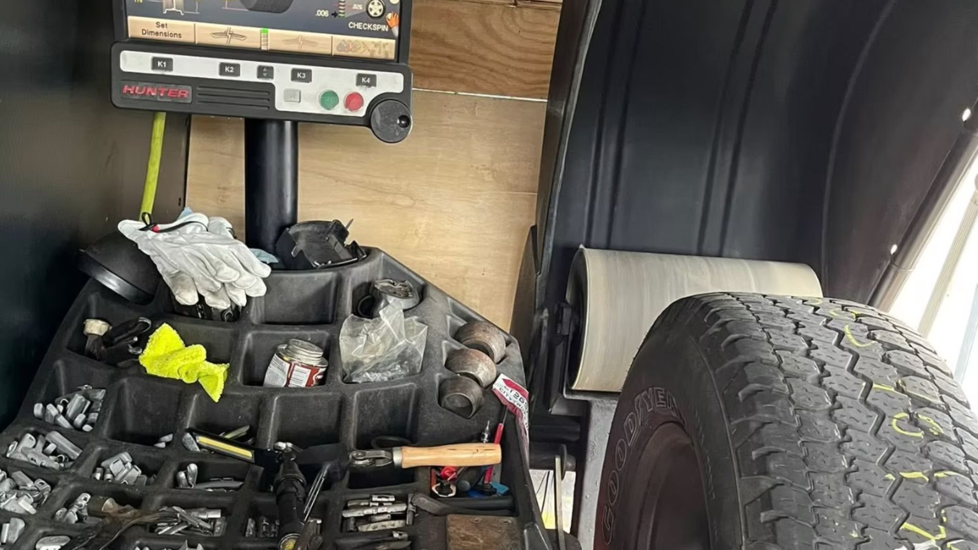 Hunter tire alignment machine with work tools and gloves in auto repair shop