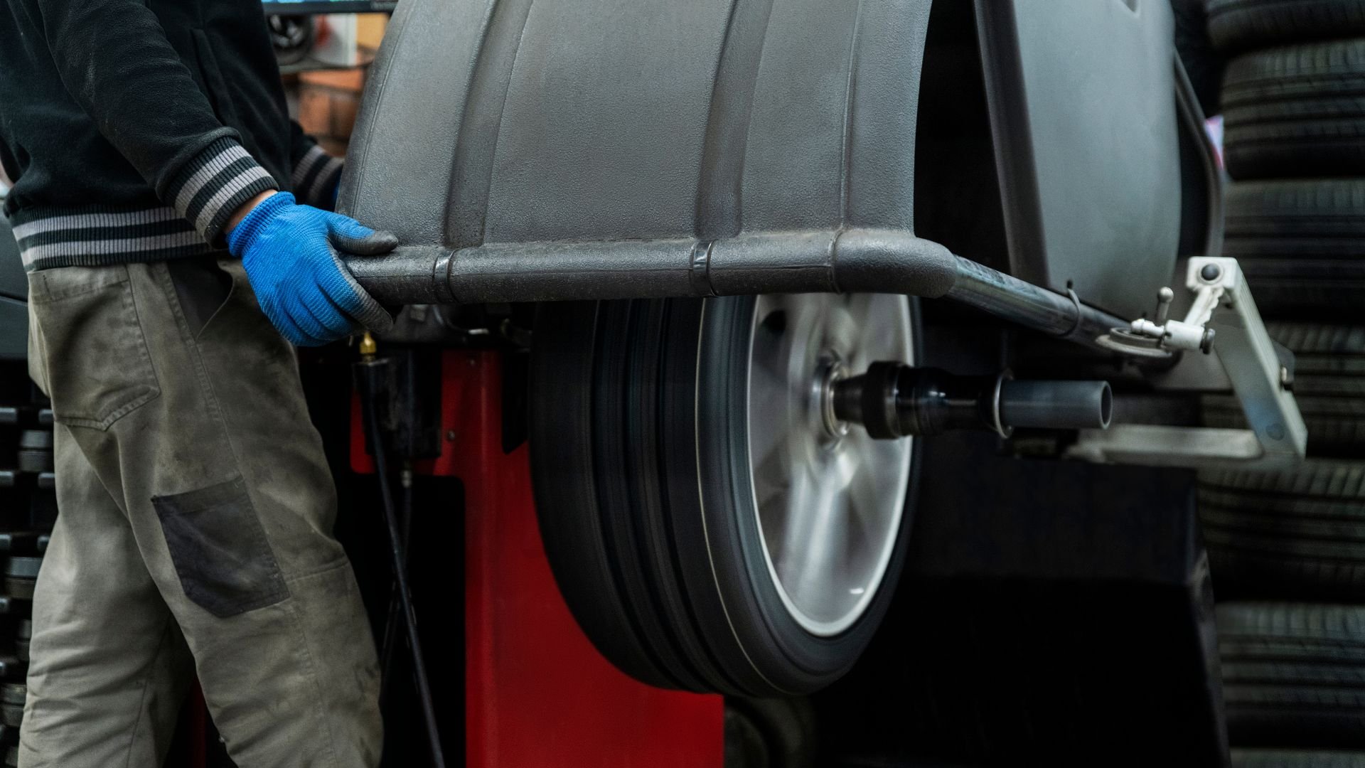 Mechanic with blue glove checking tire during vehicle maintenance