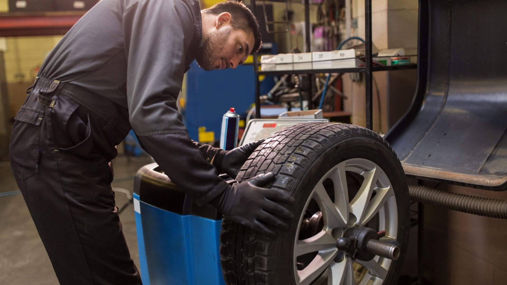 Mechanic inspecting car tire in automotive repair shop