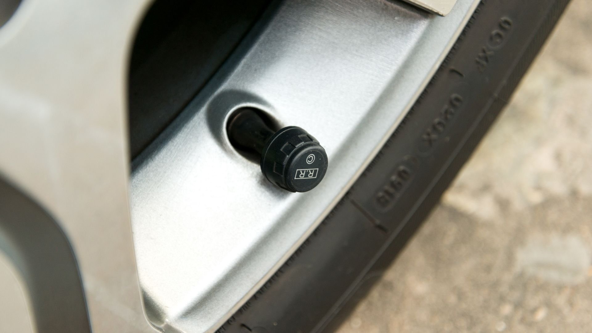 Tire pressure monitoring sensor valve cap on a vehicle wheel